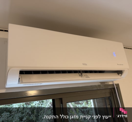 מזגן עילי לבן מסוג אינוורטר של TCL מותקן מעל חלון